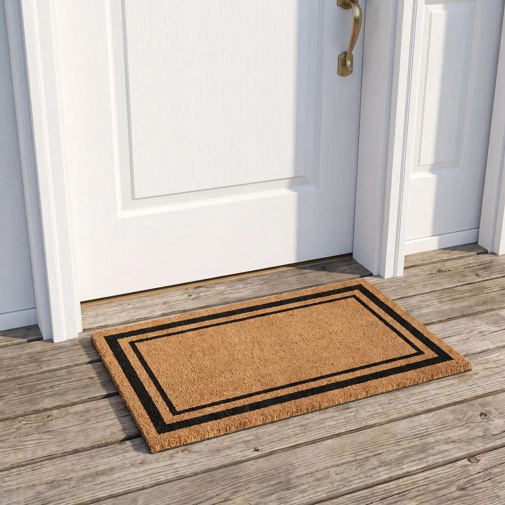 Coir doormat with a black double border on a porch