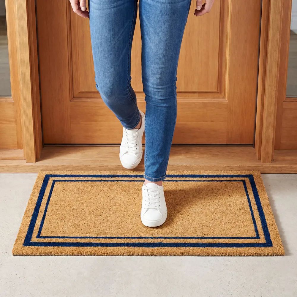 Coir doormat with a navy blue double border at a front door