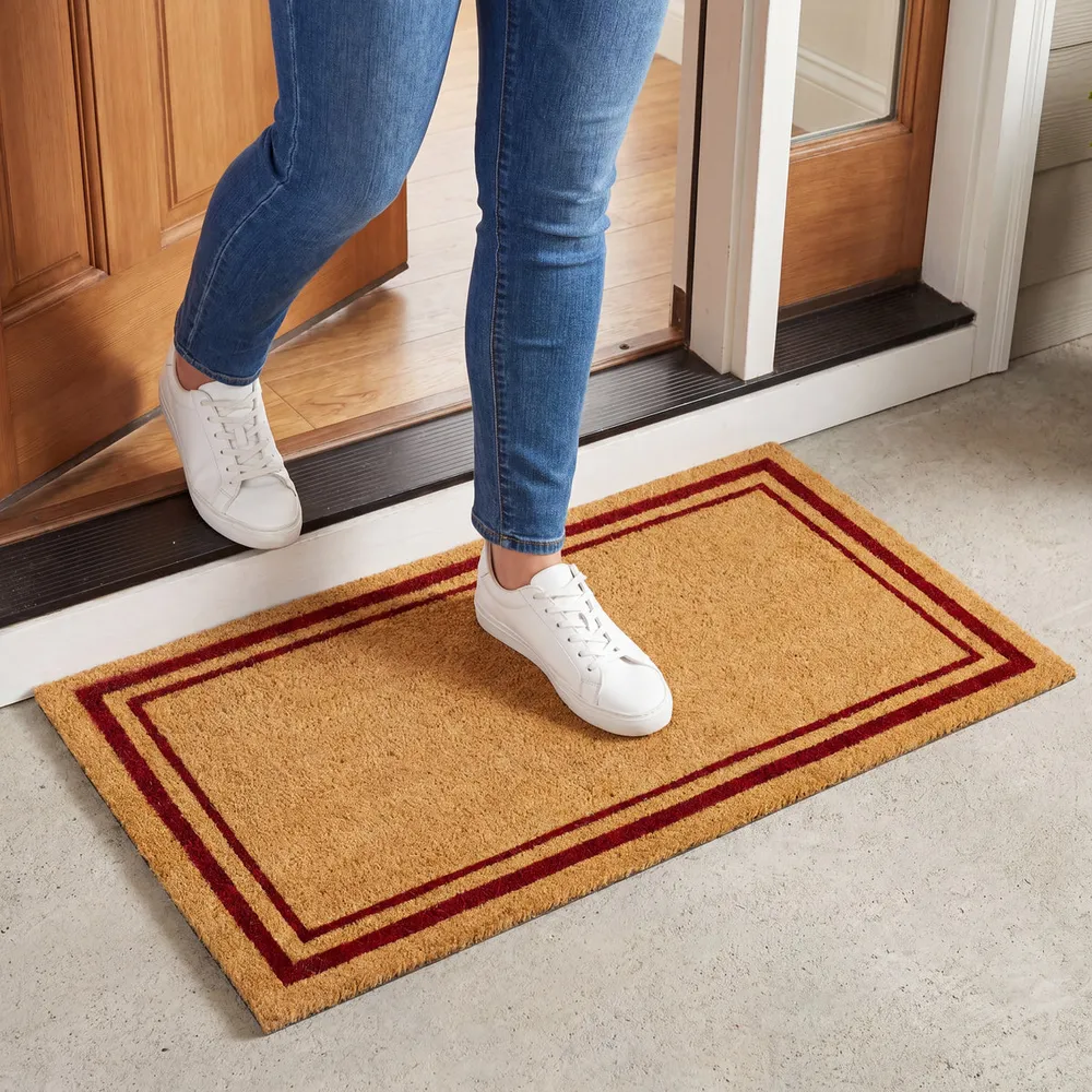 Coir doormat with a red double border at a front door